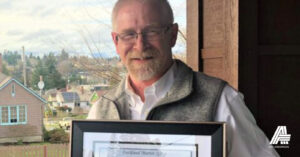 Sean Hoynes holds award