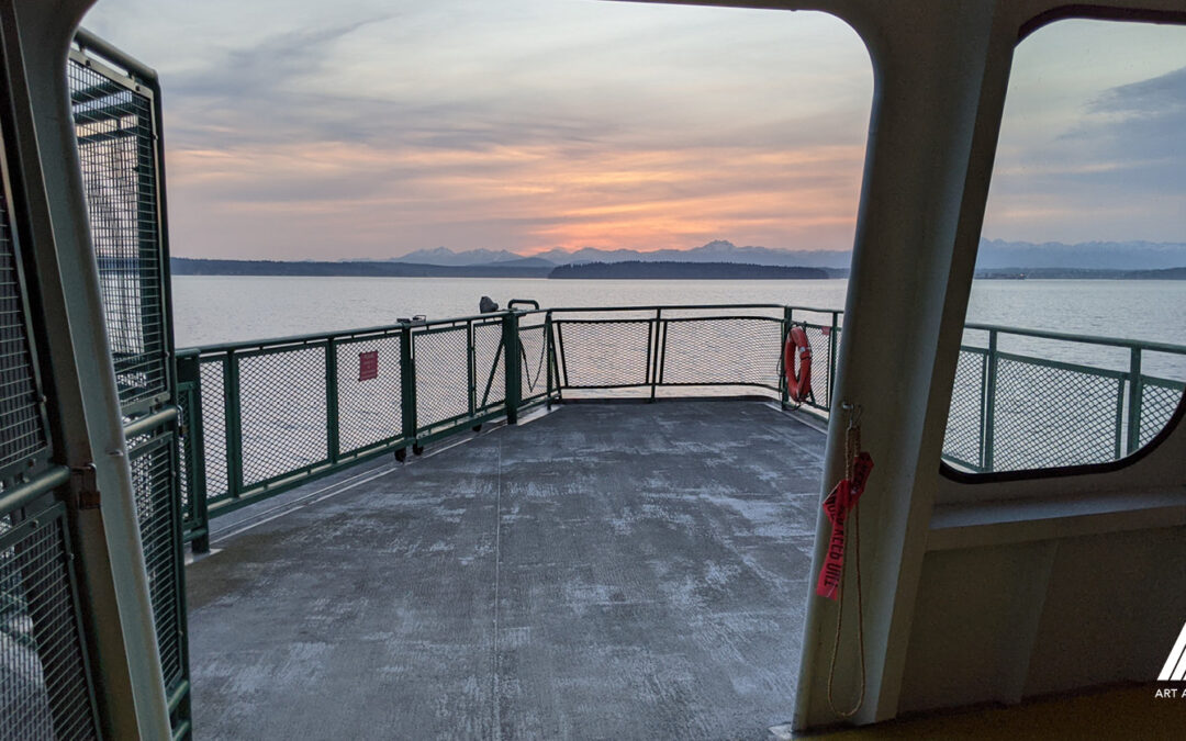 A sunset view of the Olympics from the deck of a WA State Ferry