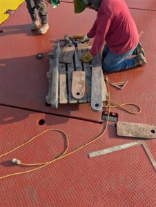metal linkages to lower the position of the spreader bar on which the electric winches were carried. 